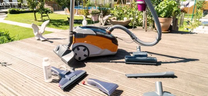 A person using a high-pressure washer to clean outdoor surfaces.